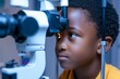 Portrait of a black child undergoing a careful vision assessment. Visual acuity examination and possible eye problems in a black child. Ophthalmology office.