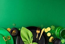 Emerald Grace: Arranging The Space For St. Paddy's Jubilee. Top View Shot Of Plates, Cutlery, Leprechaun Hat, Green Beer, Traditional Decorations On Green Background With Space For Congratulations
