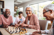 Multiracial seniors having fun during chess in geriatric clinic or nursing home
