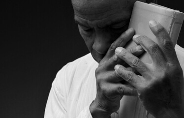 black man praying to god Caribbean man praying with black background with people stock photo	