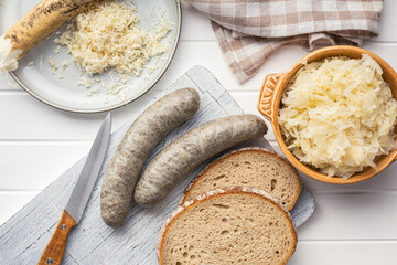 Wall Mural - White pudding sausage. Pork product on cutting board on white table. Top view.