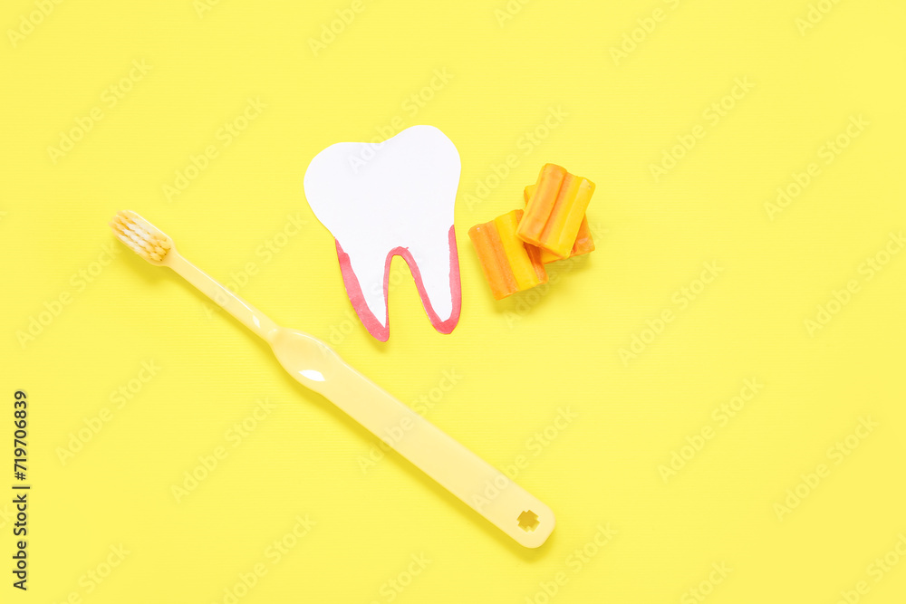 Paper tooth with brush and chewing gums on yellow background