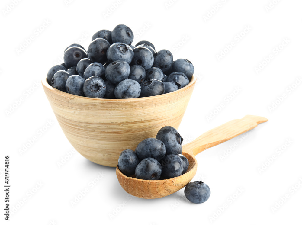 Wooden spoon and bowl with fresh blueberries on white background