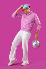 Wall Mural - Cool mature man with disco ball dancing on purple background