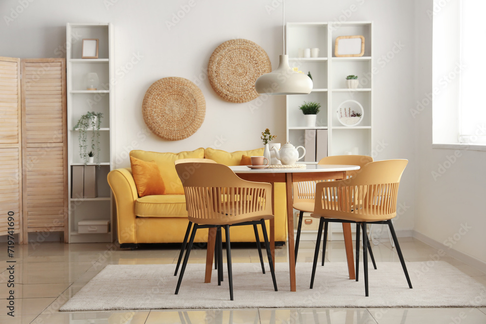 Interior of stylish living room with table, chairs and sofa