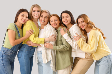 Wall Mural - Beautiful hugging women on grey background