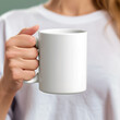 © Mrt - Woman hand holding a blank white coffee cup mockup template  with copy space for text, cup of tea, ceramic cup of coffee