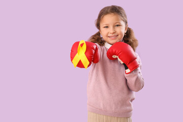 Sticker - Cute little girl in boxing gloves with yellow ribbon on lilac background. Childhood cancer awareness concept