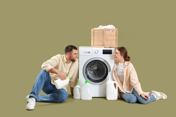 Wall Mural - Young couple doing laundry on color background