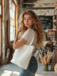 © AdrianGomezFoto - Young and pretty woman dressed in casual clothes, jeans and a basic t-shirt. She carrying a plain white bag. Space for text or logo. The girl is in a rustic decoration business.