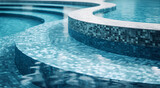 Fototapeta  - Curved lines of a tranquil blue mosaic-tiled pool reflect the calmness of still water.