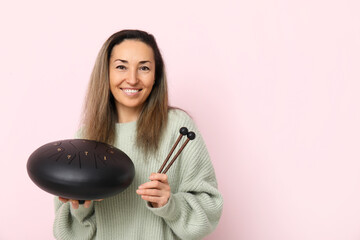 Canvas Print - Happy mature woman with glucophone and sticks on pink background