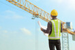 © Kwangmoozaa - construction engineer worker in protective helmet and blueprints paper on hand at building site background