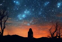 Silhouette of a woman sitting on the hill and looking at the milky way
