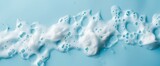 Fototapeta  - spot of thick shampoo foam on a blue background. top view. copyspace along the perimeter, generative AI