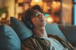 Rest And Relax Concept. An Asian man sits calmly on the couch listening to music, audiobooks, and podcasts, meditating for peace of mind and sleep, and wearing wireless headphones.