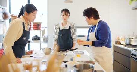 Wall Mural - Japan, chef and cooking in kitchen with teaching for recipe, Japanese cuisine and healthy meal in restaurant. People, women and traditional lunch with learning or instruction for dinner and culture