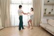 © Hip.hub - Beautiful young people dancing at home. Valentine's Day concept. Lovers at home celebrating Valentine's Day.