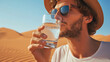 Man enjoying a glass of water in middle desert during a heatwave