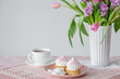 cup of tea and cupcakes with spring flowers in light colors