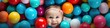 Top view to baby infant with colorful plastic balls around, playful image