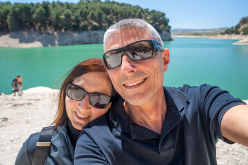 Wall Mural - A happy couple relaxing along a beautiful lake