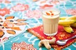 glass of peanut butter banana smoothie on a patterned tablecloth with fresh ingredients