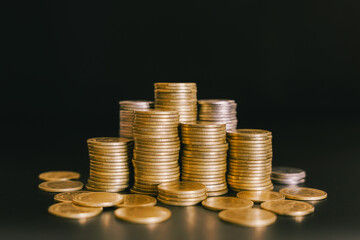 Golden money coin stack on black background. Symbolizing wealth, success, and financial growth in banking and business.