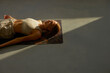 Young woman practicing corpse asana in yoga studio. Savasana pose.
