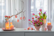 easter home decor with flowers, eggs, burning candles