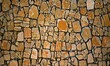 small stone pebbles wall style decorative design real stone wall surface cracked with cement. The old walls are made of stones. Vintage rough block surface background