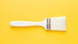 Paintbrush with white paint on a yellow background, moc up design concept