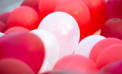 Wall Mural - Colorful balloons on red and white background, close-up.