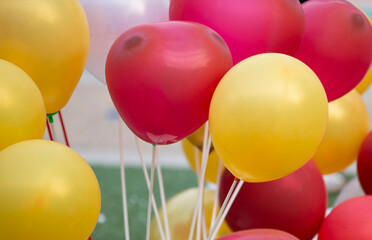 Wall Mural - Colorful balloons on red and white background, close-up.