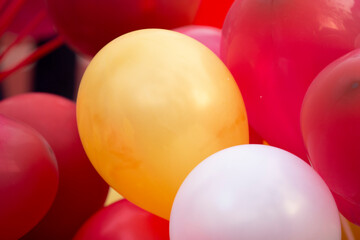 Wall Mural - Colorful balloons on red and white background, close-up.