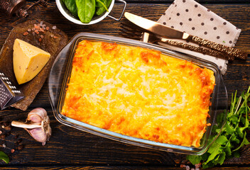 Poster - Rectangular glass bowl filled with mashed potato, underneath which is fish in cheese sauce.