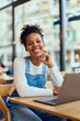 © bnenin - Portrait of a smiling African woman, working from the cafe, over the laptop.