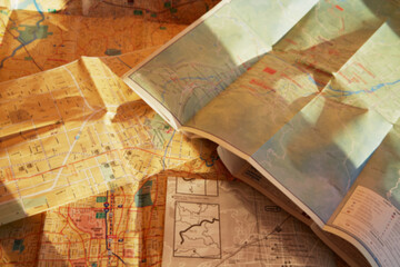 Blurred image of stacked paper maps, trip planning, route selection, tourist maps.