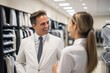 © Iftikhar alam - A man and woman engage in conversation while inside a clothing store, Smiling salesman discussing over product with female customer, AI Generated