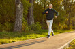 © Studio Romantic - Elderly sporty male runner jogging in city park. Healthy happy smiling senior man running outdoors training for wellness, health and cardio. Workout in nature and healthy lifestyle concept.