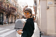 © PhotoBook - Outside portrait of lovely cute girl is posing to camera with smile in modern glasses