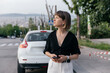© PhotoBook - Profile outdoor portrait of stylish pretty girls with smartphone in front of car