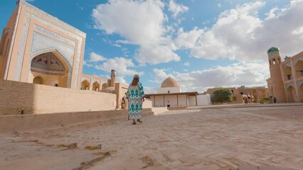 Wall Mural - Woman in ethnic dress near Madrassah in Ichan Kala of Khiva