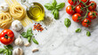 A gourmet cooking flat lay with fresh ingredients for Italian cuisine including tomatoes basil olive oil pasta and garlic on a marble countertop.