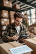 © piai - An entrepreneur calculating taxes on a digital device, warehouse boxes background