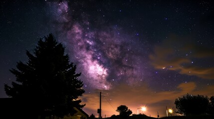 Wall Mural - Silhouette of suburban street lights with the dramatic Milky Way star cluster and nebula clouds in the background.