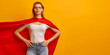 © JW Studio - Confident woman wearing superhero cape on yellow background with copy space.