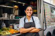 young hispanic American woman chef serving takeaway food in food truck