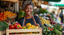 Portrait Of A Black Female Working At A Farmers Market Stall With Fresh Organic Agricultural Products. African Businesswoman Holding A Crate With Fruits And Vegetables, Looking At Camera And Smiling