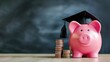 Piggy bank wearing a graduation cap on a wooden table with coins stacked beside it, symbolizing student loan. Chalkboard or blackboard on background